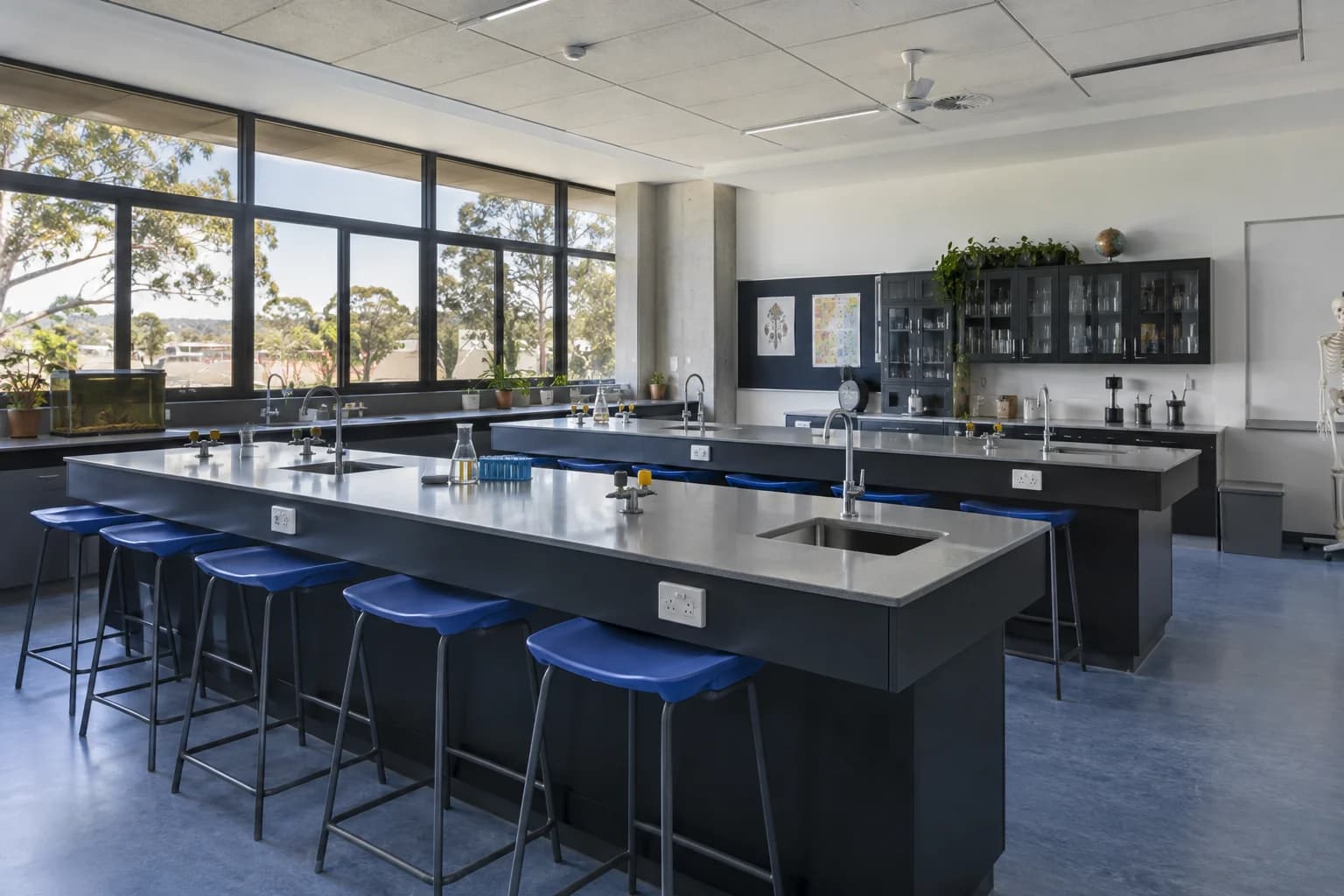 Illustrative school science classroom with lab benches and blue stools